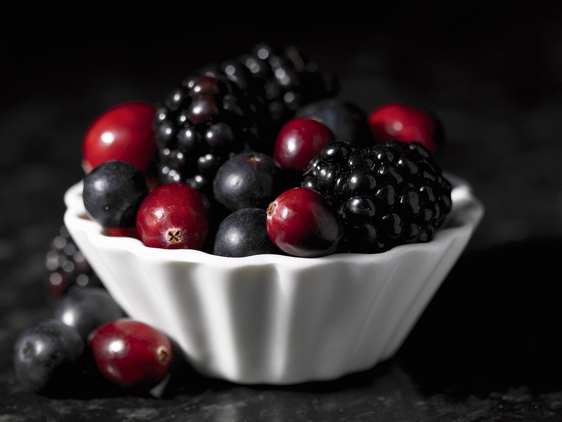 Cranberries, blueberries and blackberries in a small dish