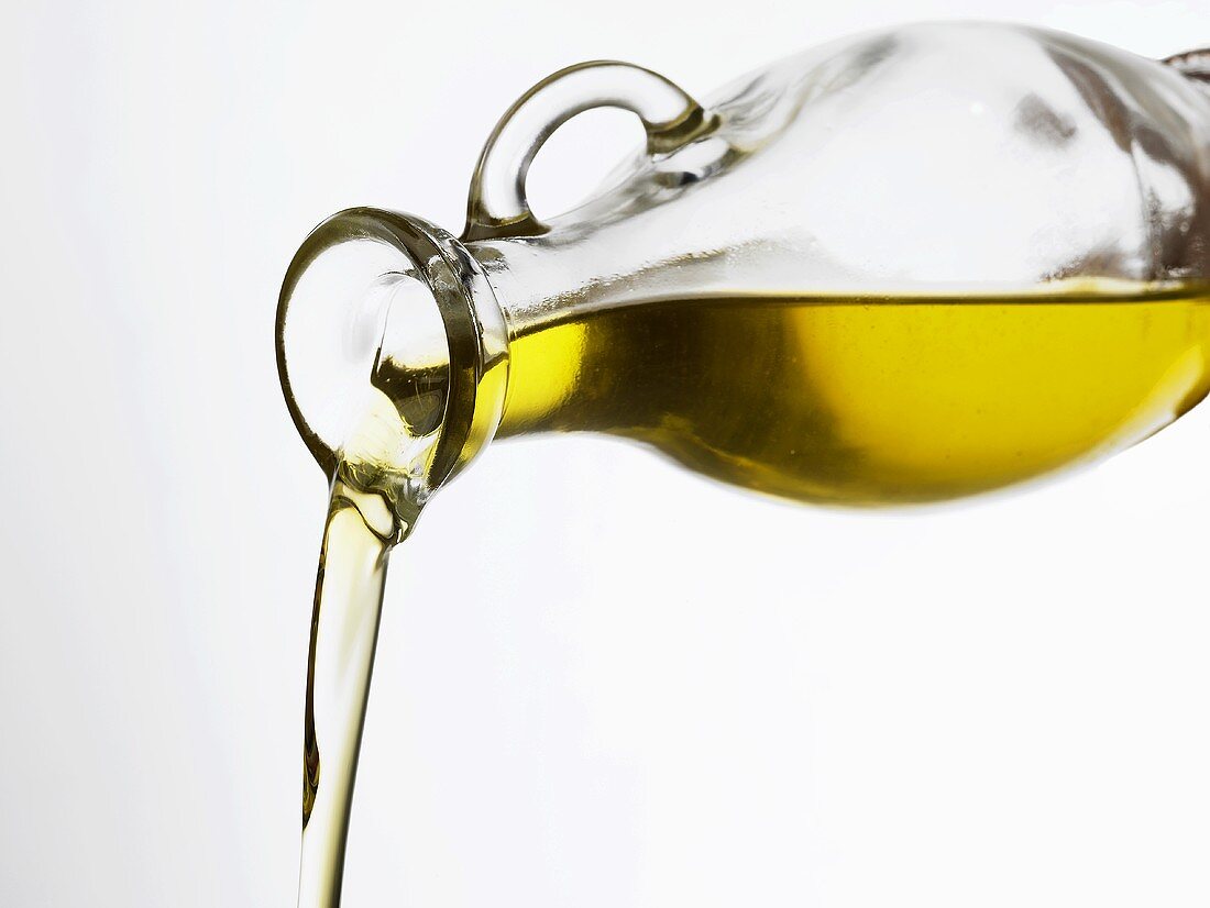 Olivenöl aus einer Karaffe gießen