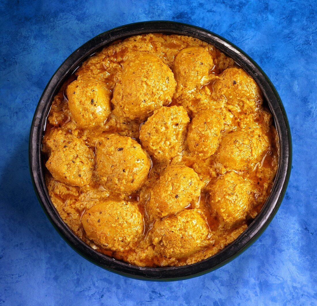 Kartoffelbällchen mit Trockenfrüchten gefüllt in Currysauce