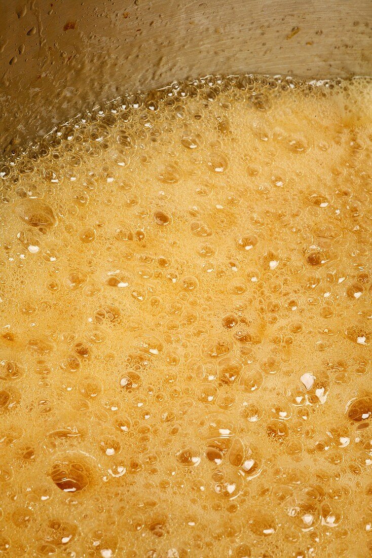 Orange marmalade boiling in a pan