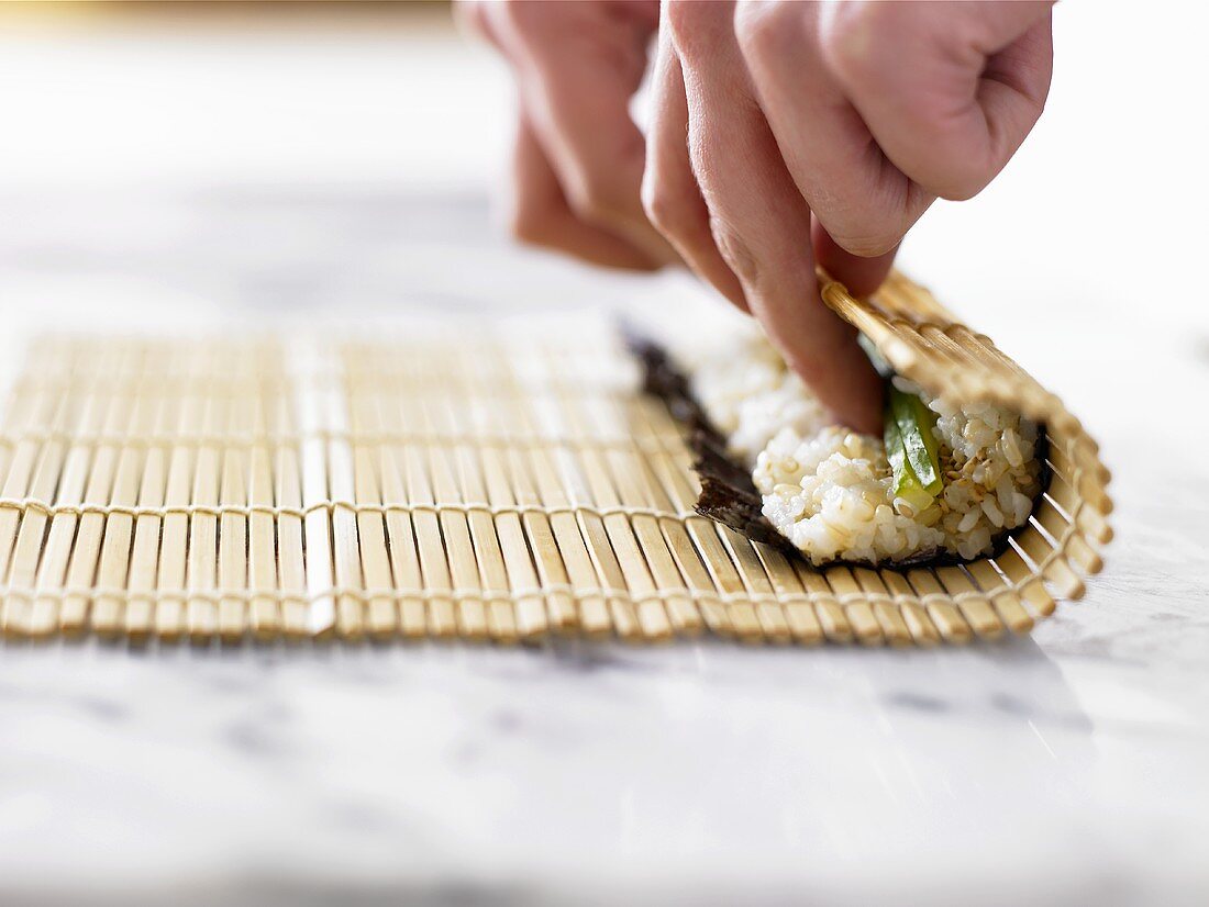 Making maki sushi (rolling up with a bamboo mat)