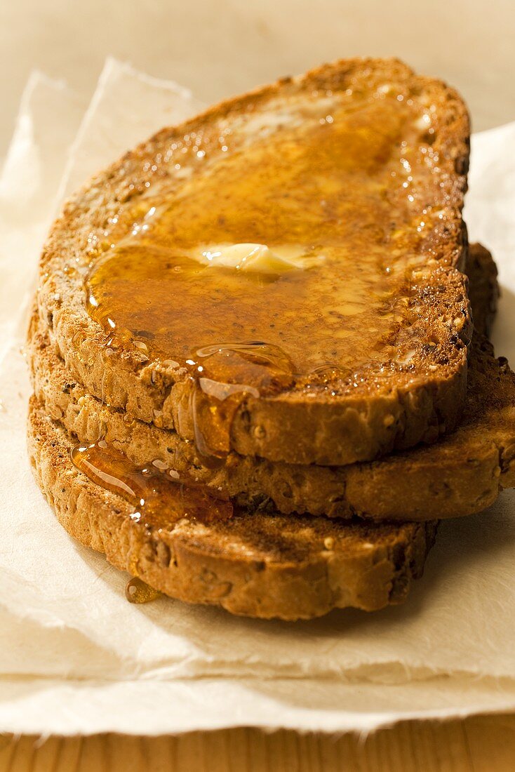 Getoastete Vollkornbrotscheiben mit Butter und Honig