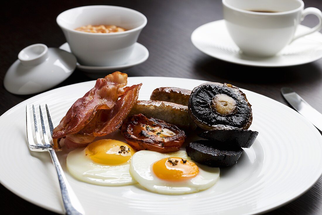 Englisches Frühstück mit Spiegelei, Bacon, Pilzen, Bratwurst