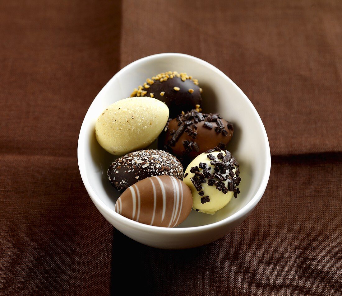 Several chocolate truffle eggs in a small bowl
