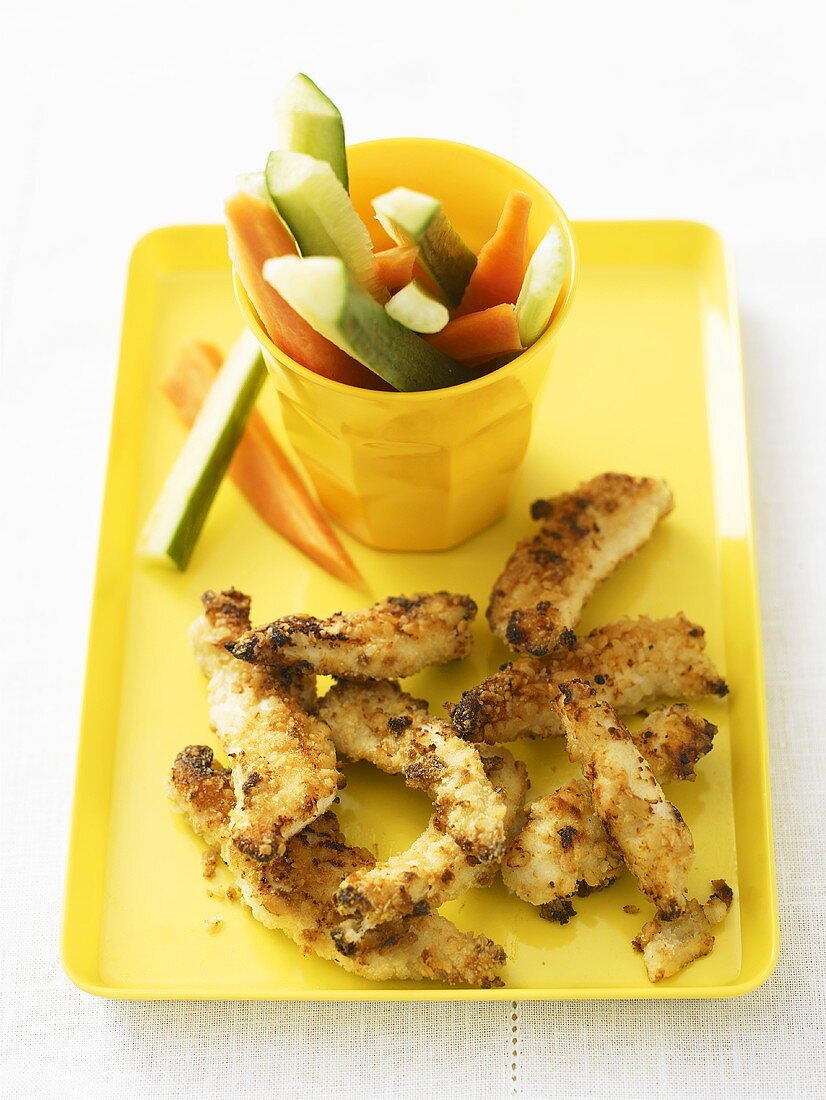 Breaded strips of chicken with vegetable sticks