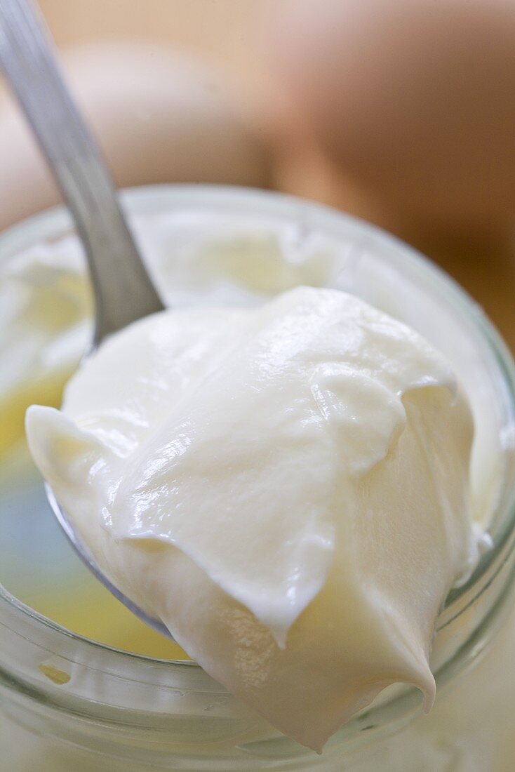 Mayonnaise auf einem Löffel mit Glas