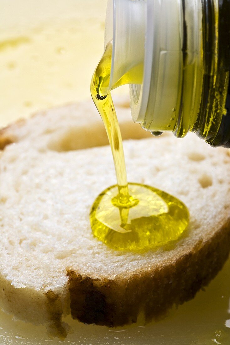 Pouring olive oil onto white bread