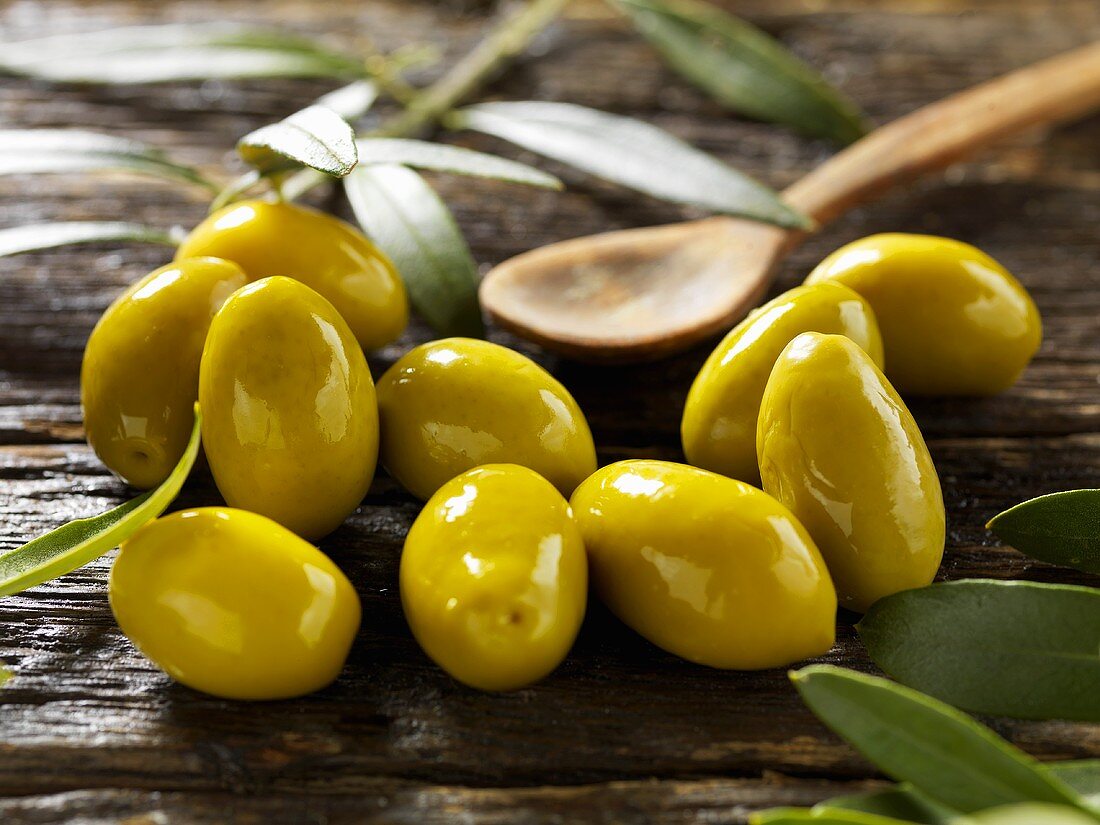 Green olives on wooden table