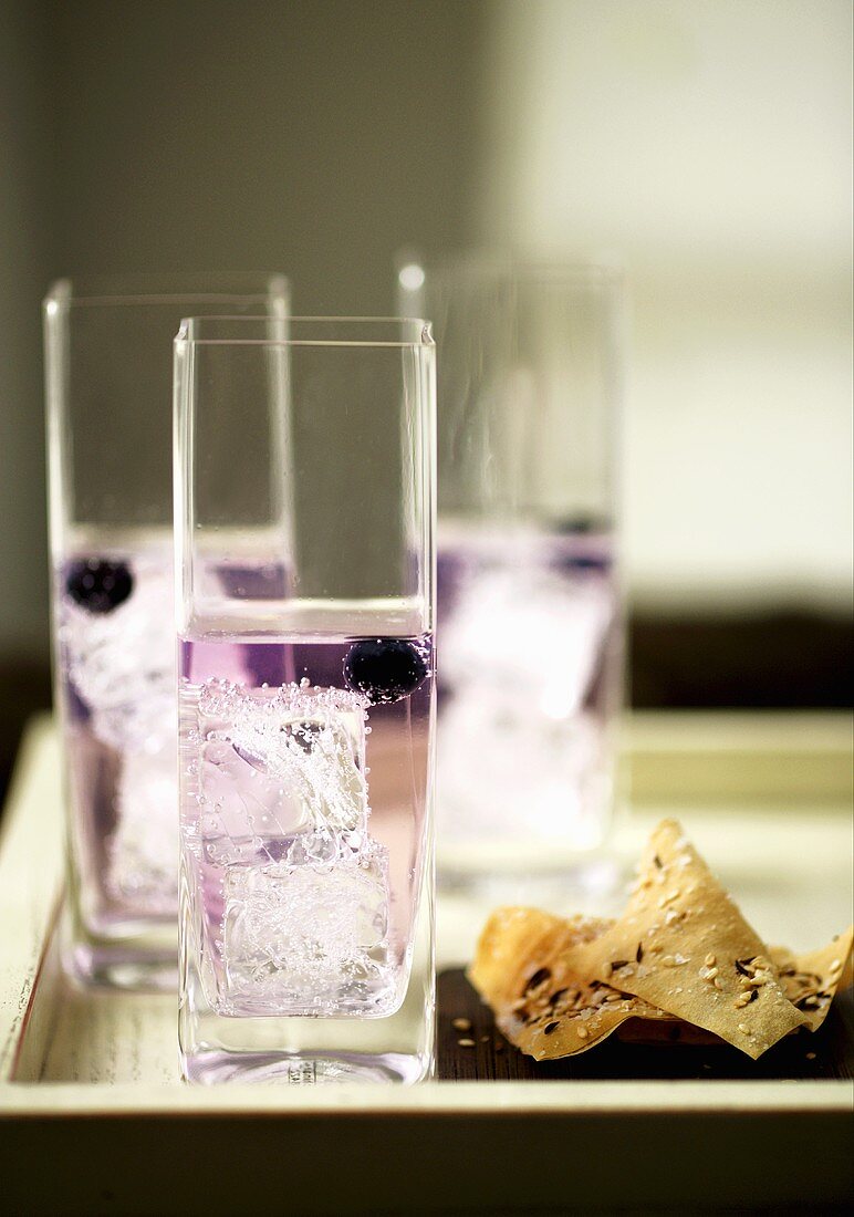 Schlehen-Gin in drei Gläsern mit Eiswürfeln