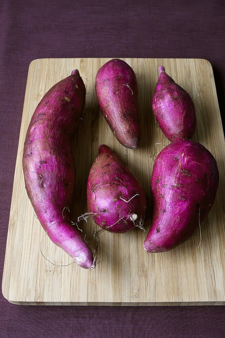 Purple sweet potatoes on wooden board