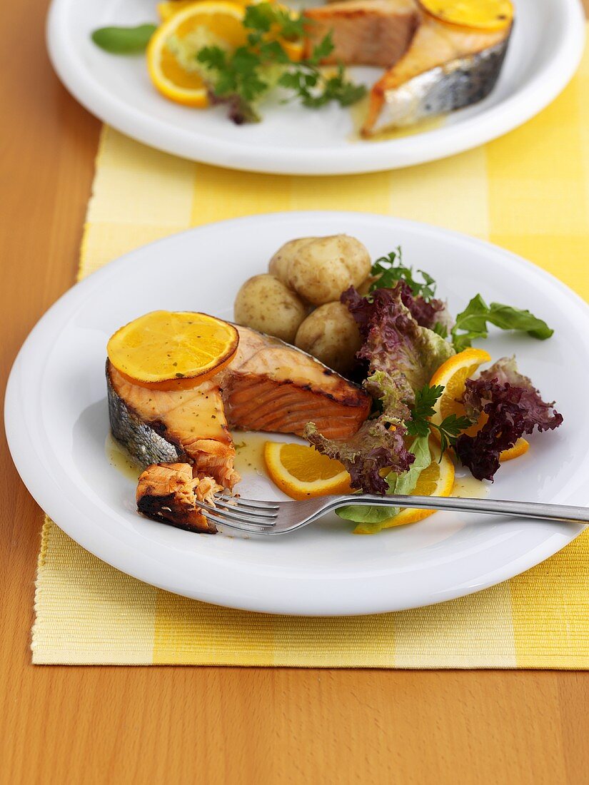 Salmon steak with orange slices and potatoes