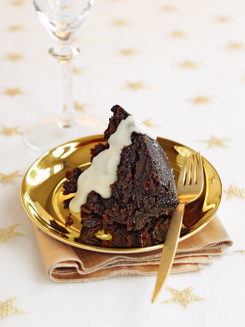 A portion of Christmas pudding with rum sauce (UK)