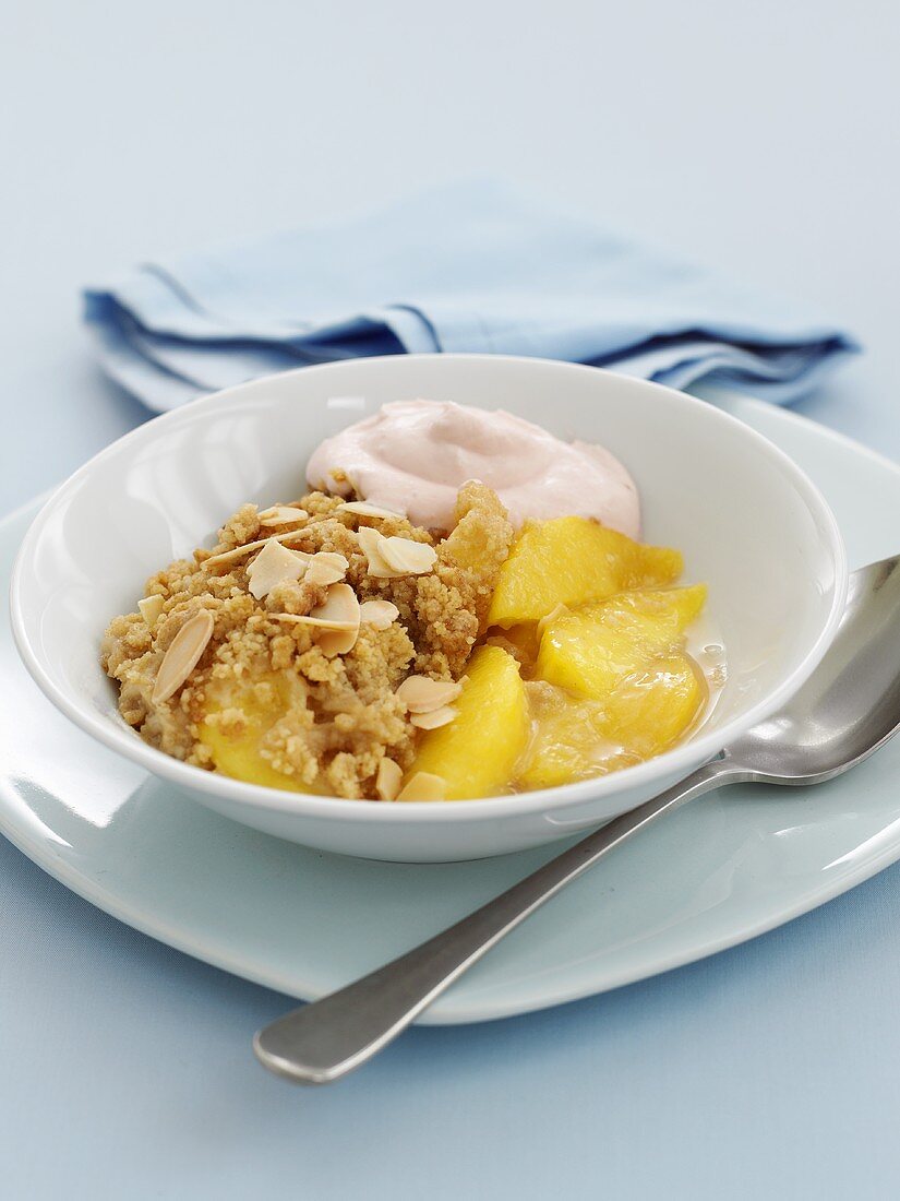 Peach crumble with flaked almonds in dish