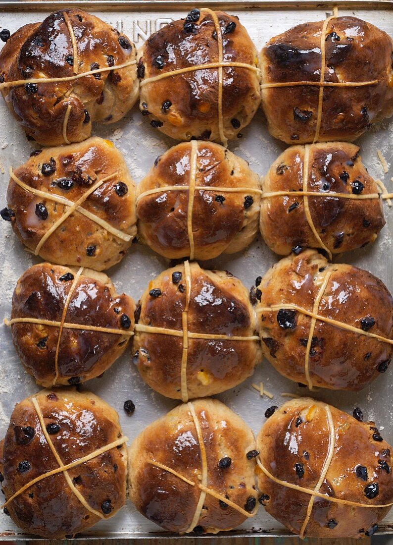 Twelve hot cross buns on a baking tray