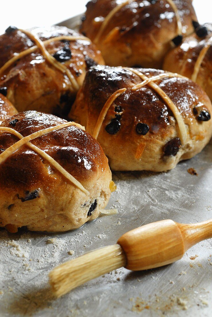 Hot Cross Buns auf einem Backblech mit Pinsel