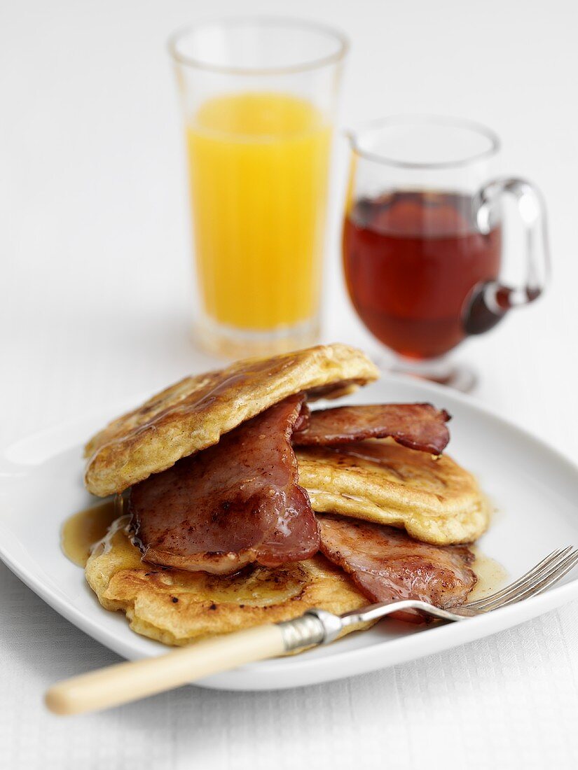 Pancakes with bacon and maple syrup, orange juice