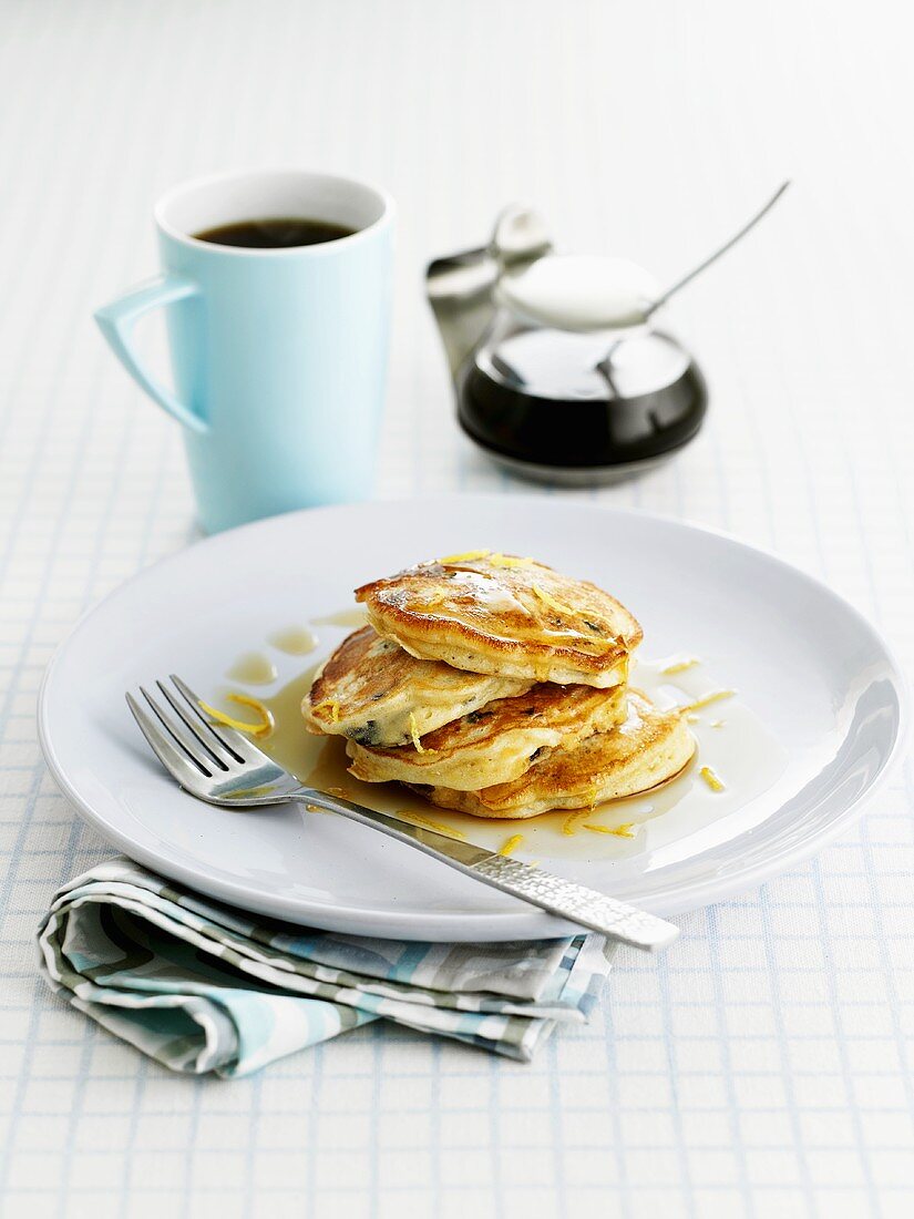 Pancakes with lemon zest and maple syrup, cup of coffee