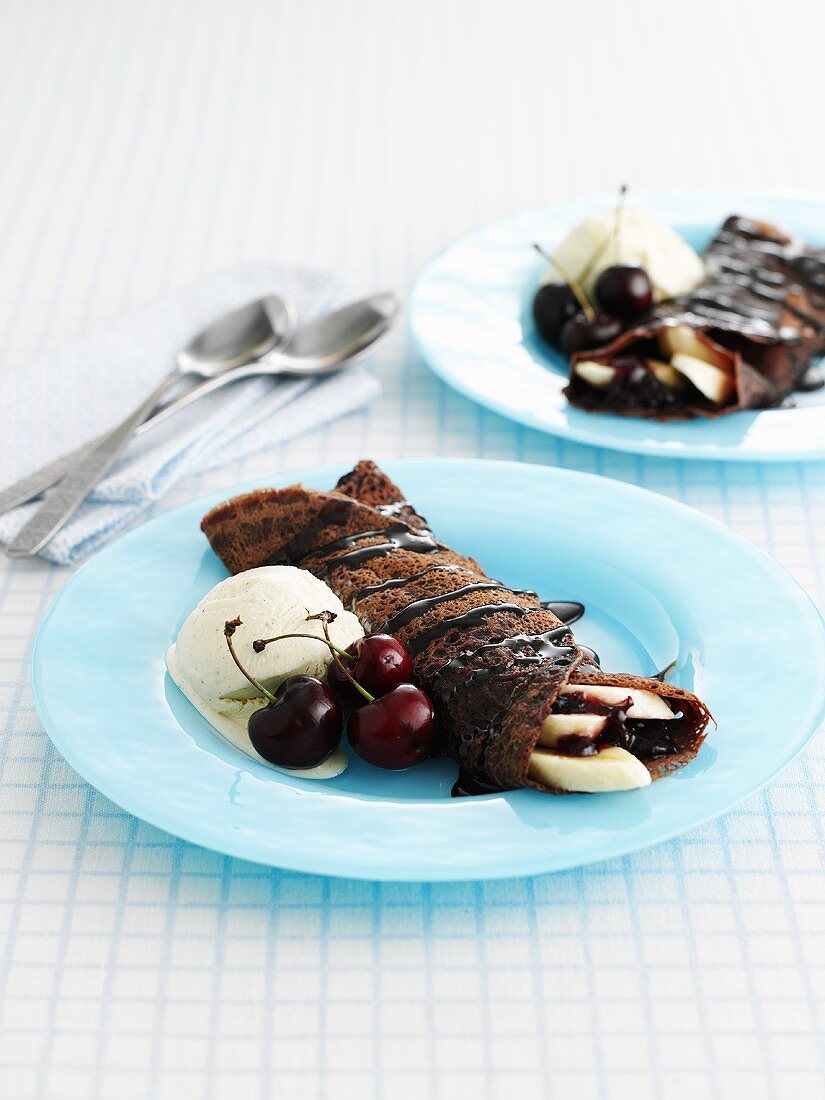 Chocolate pancakes with banana, cherries and vanilla ice-cream