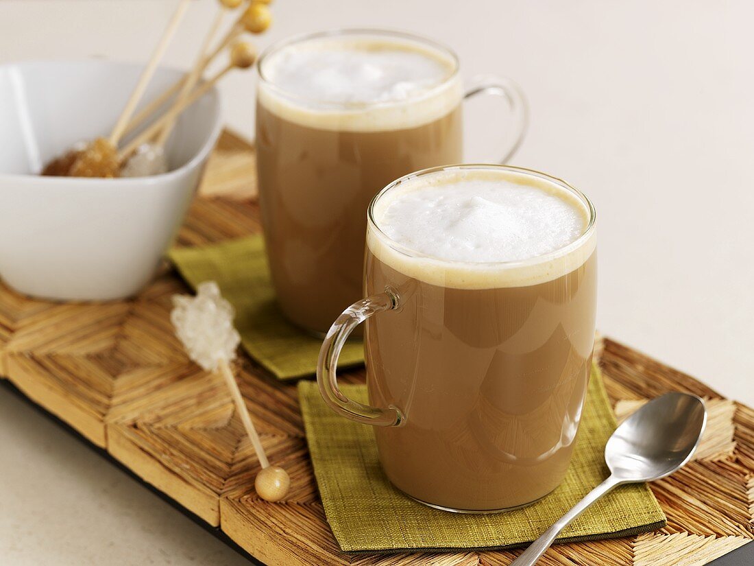 Zwei Gläser Milchkaffee und Kandissticks