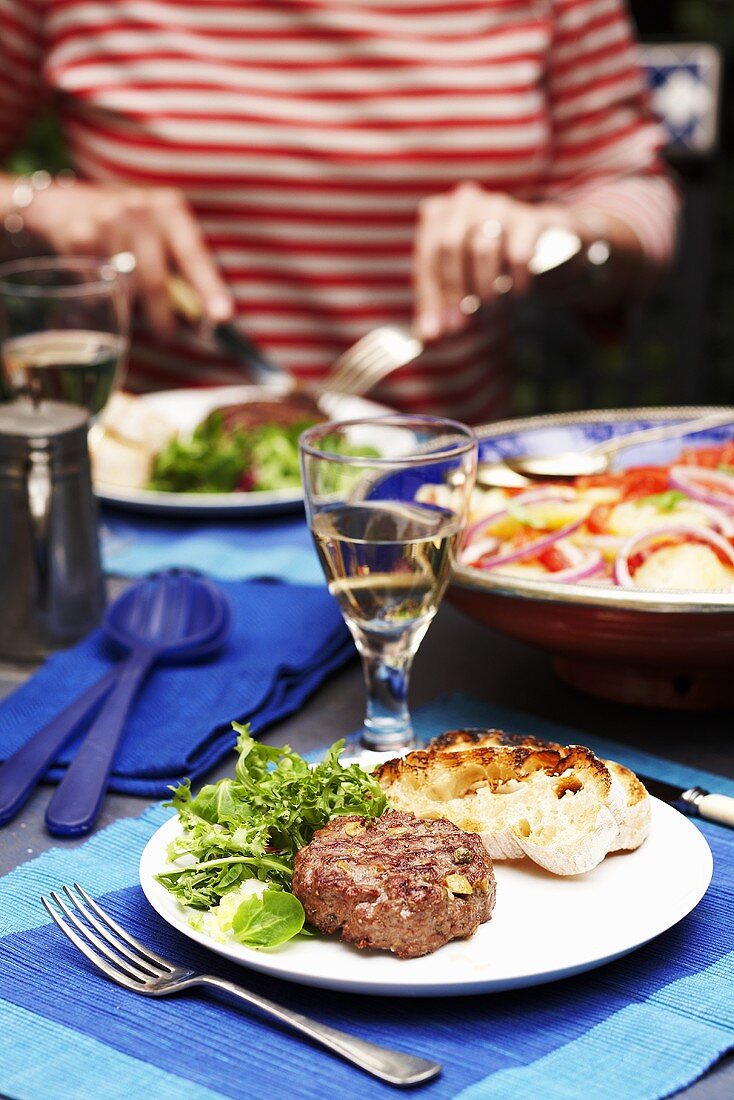 Woman eating burger with salad