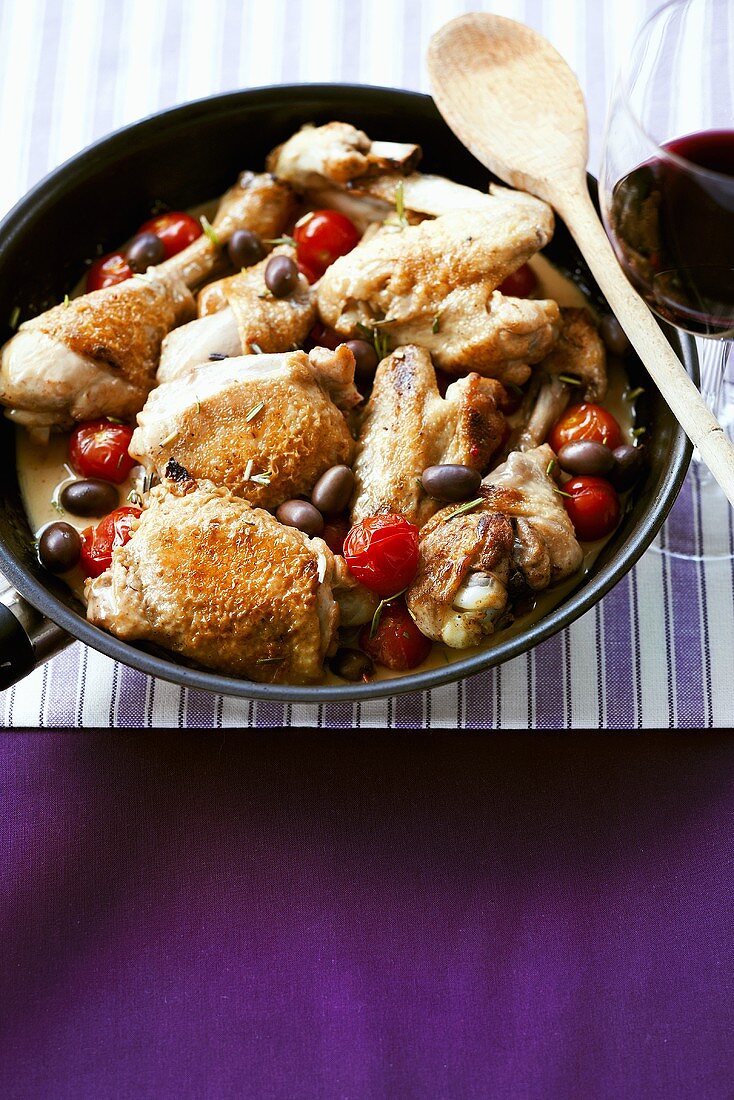 Chicken pieces braised in white wine sauce with tomatoes & olives