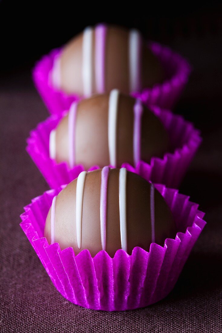 Three chocolates in purple paper cases