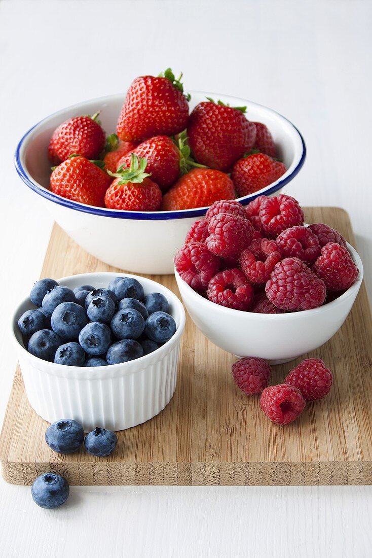 Strawberries, blueberries and raspberries in bowls