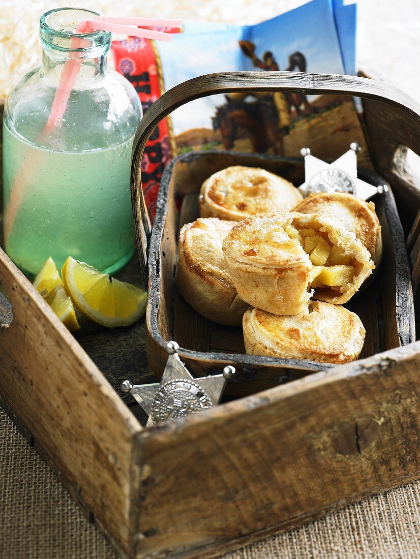 Mini apple pies and lemonade in a wooden box
