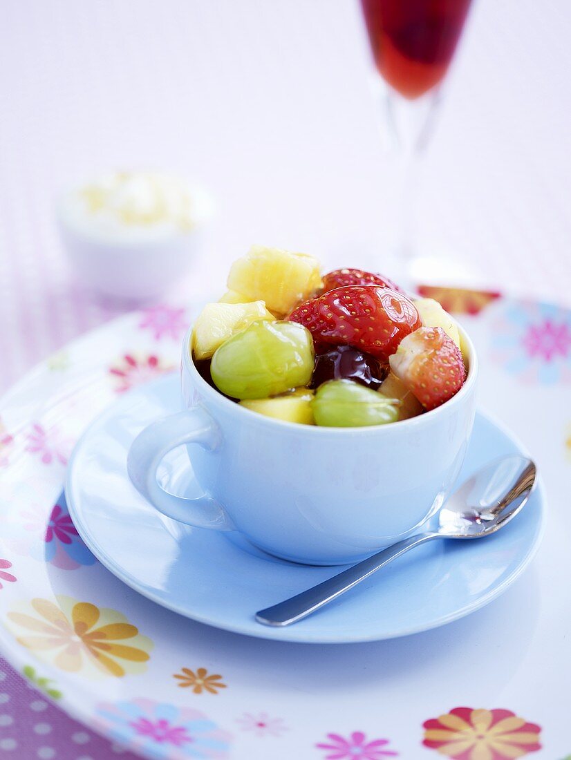 Obstsalat mit Honig in einer Tasse