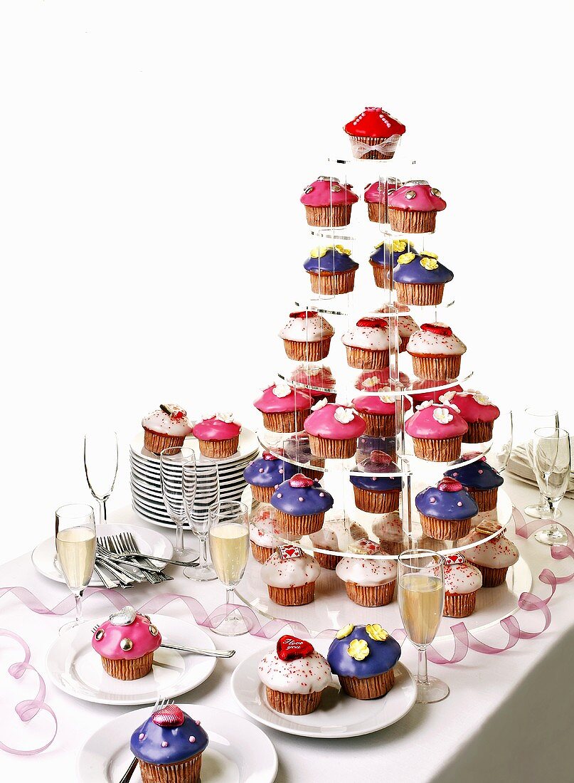 Colourful muffins on a tiered stand with sparkling wine