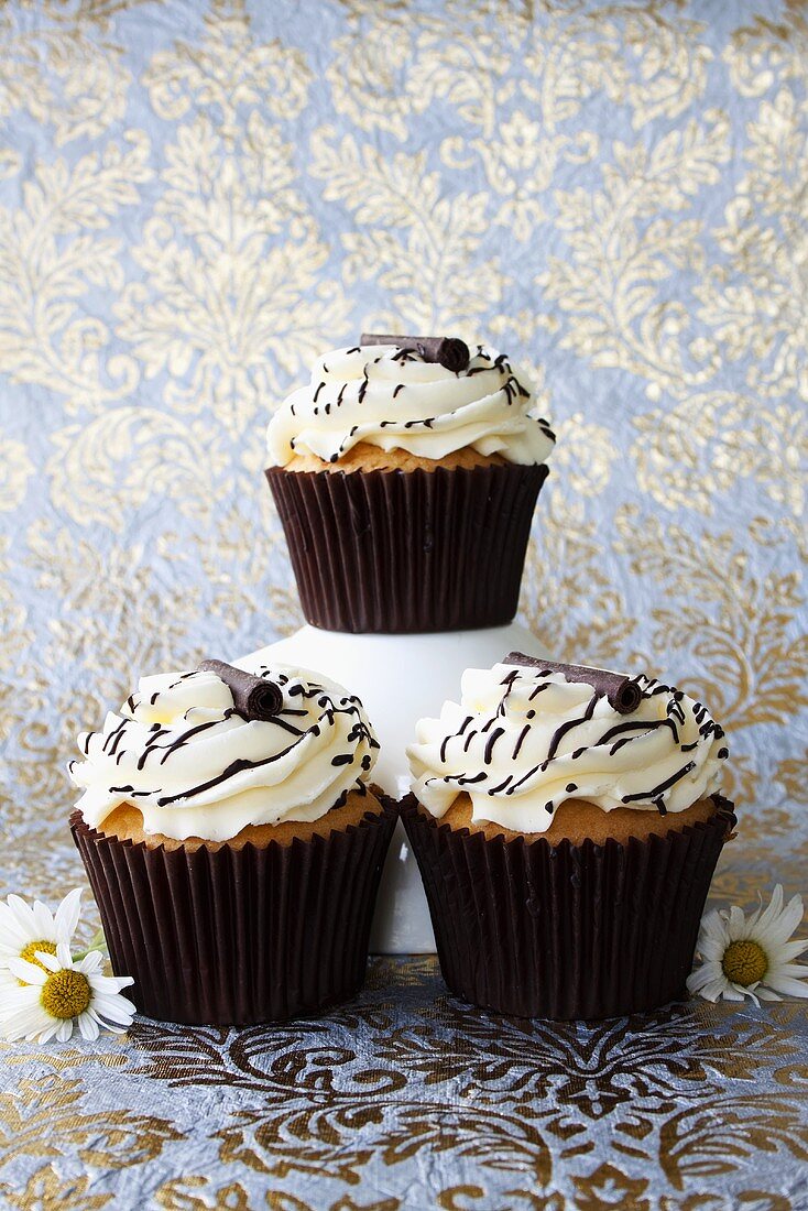 Muffins with cream topping and chocolate decorations