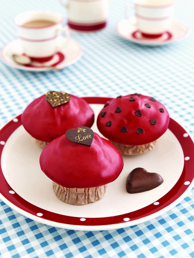 Muffins with red icing and chocolate hearts, with tea
