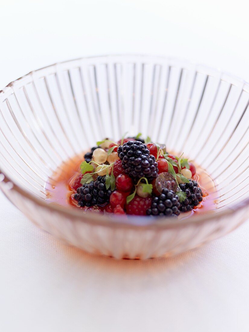 Berries with sauce in glass bowl