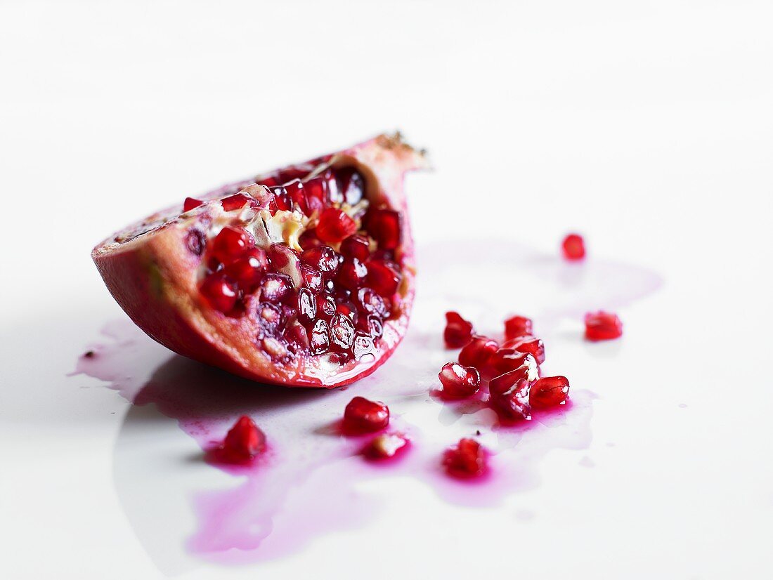 Wedge of pomegranate and pomegranate seeds