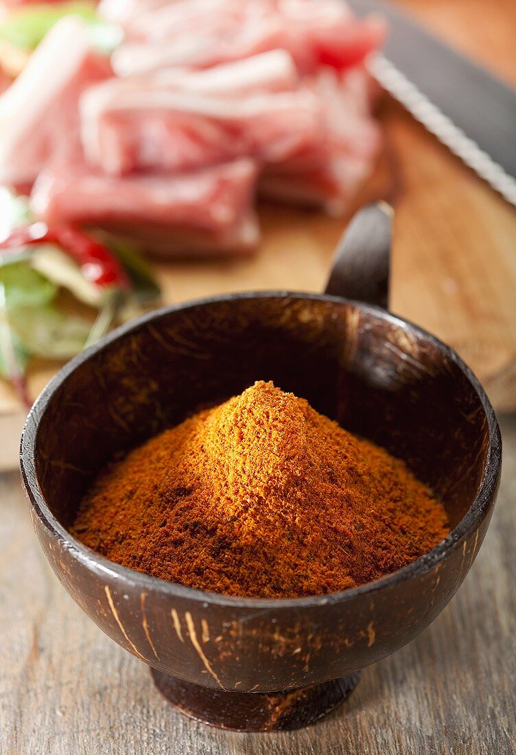 Curry Nihari Gewürzmischung in einer Schale, im Hintergrund Lammfleisch