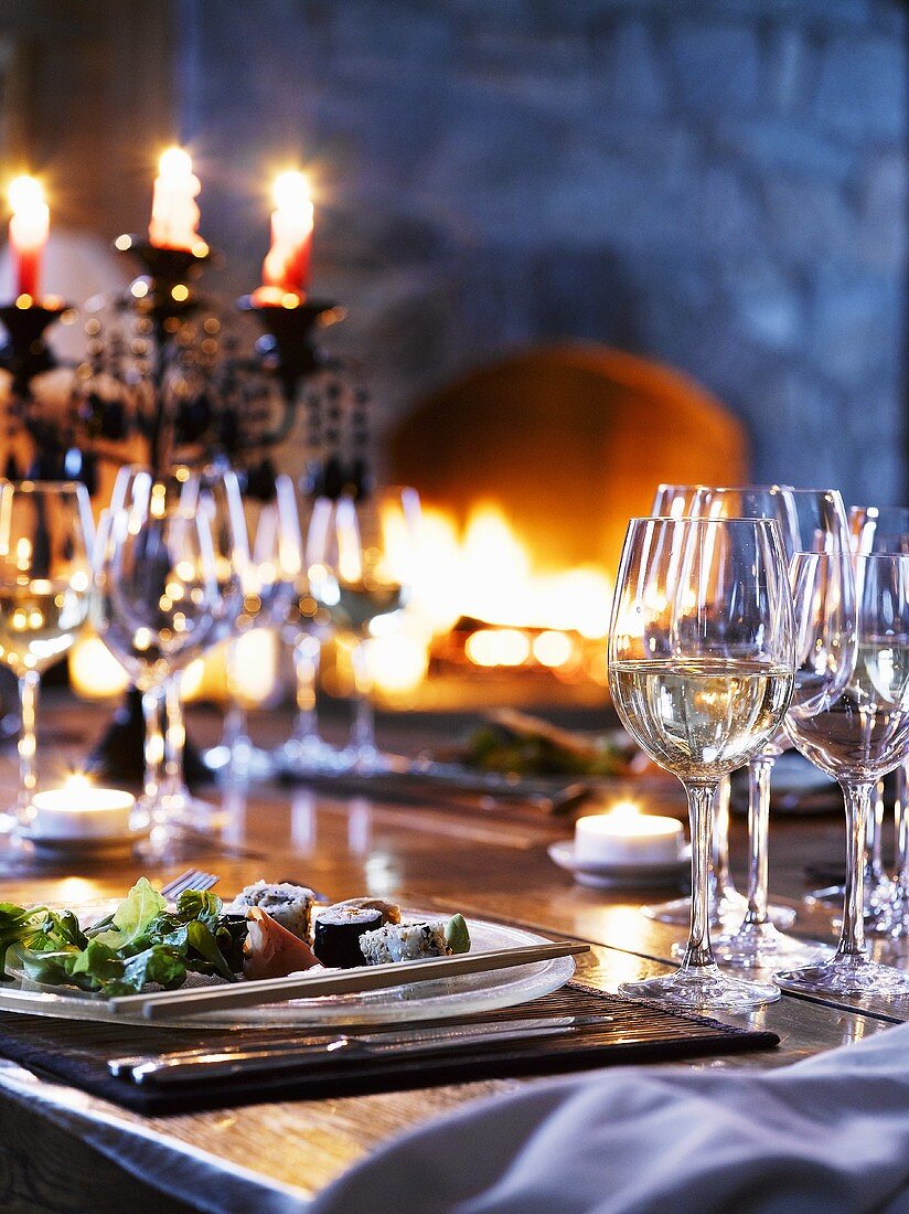 Sushi on laid table in front of fire