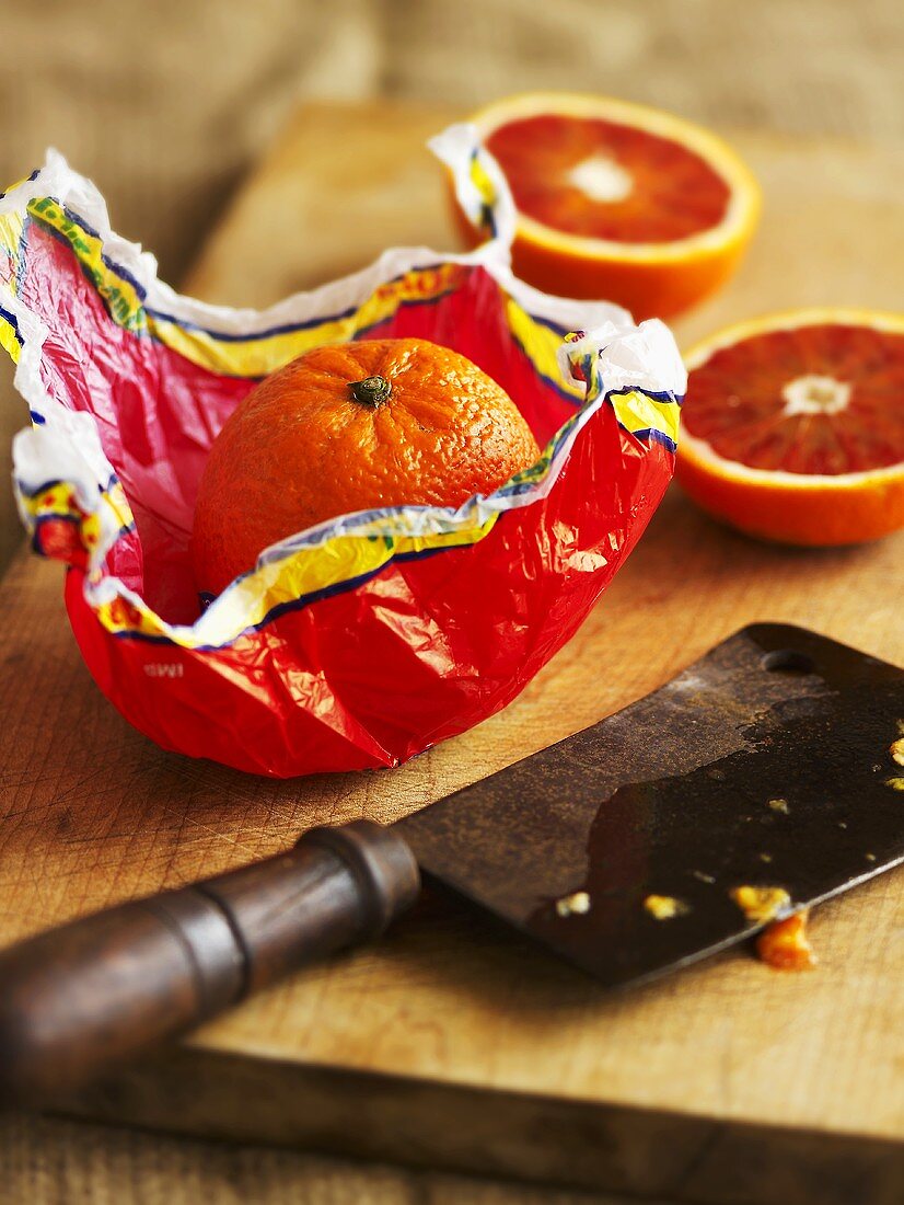 Blood orange wrapped in paper and halved blood orange
