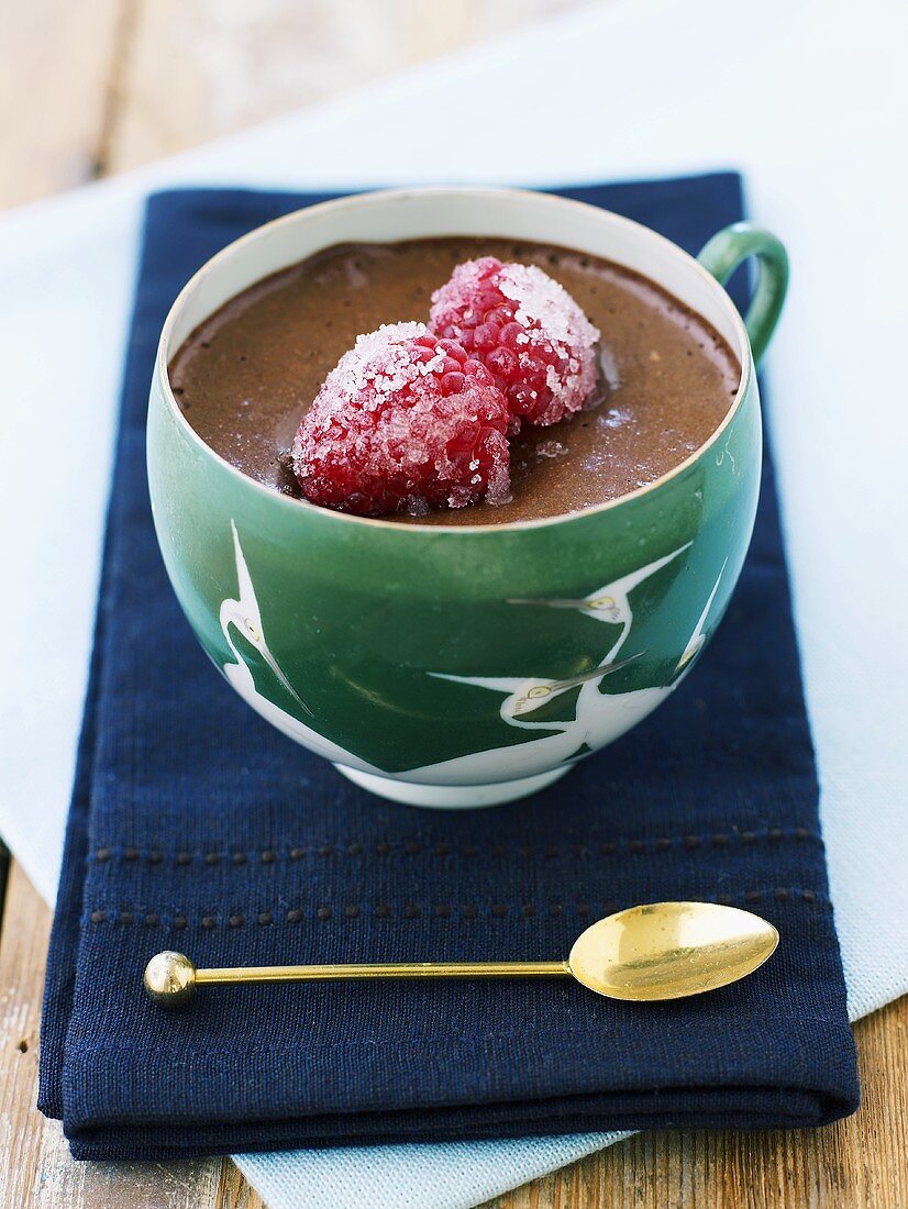 Chocolate pudding with sugared raspberries in a cup