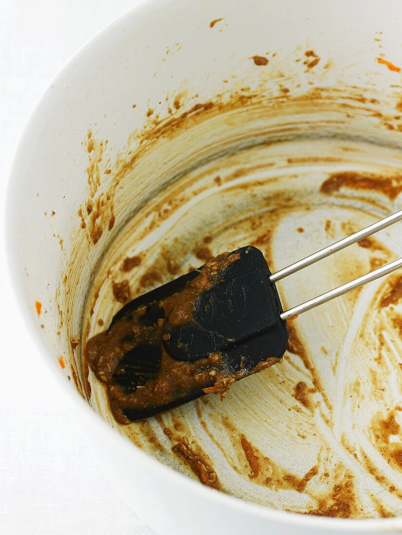 Empty bowl with the remains of carrot cake mixture, spatula