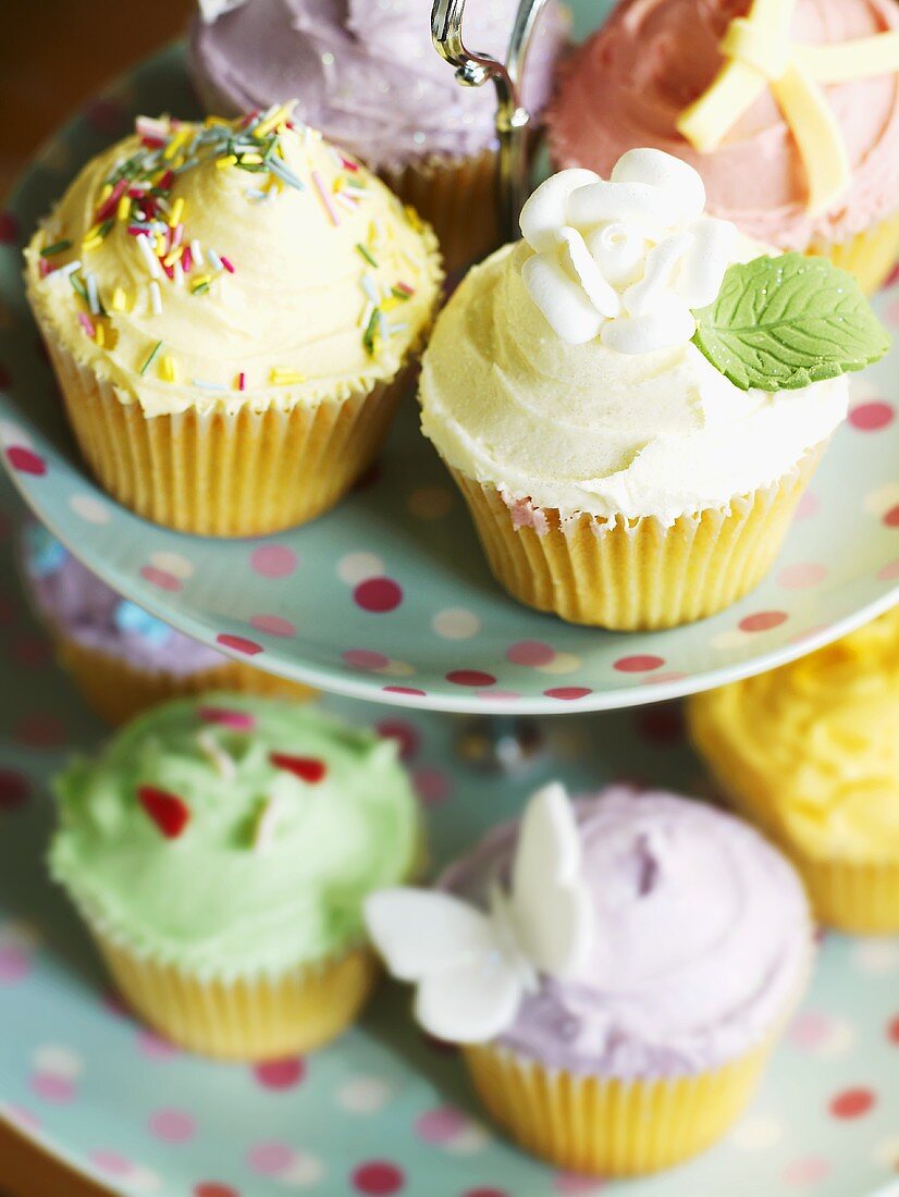 Cupcakes with different decorations on tiered stand