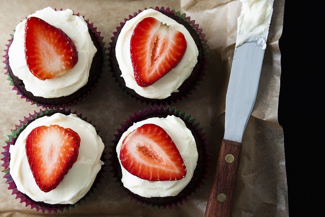 Chocolate muffins with strawberries and cream