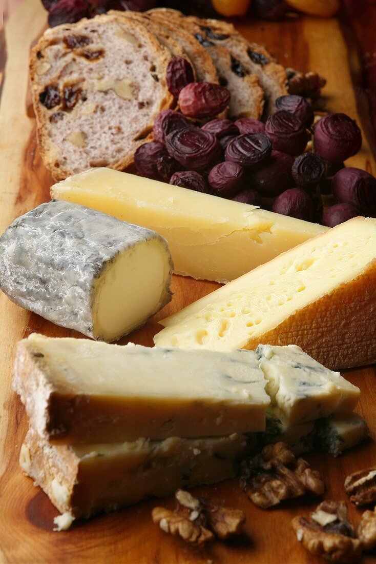 Cheese board with walnuts, dried grapes and bread