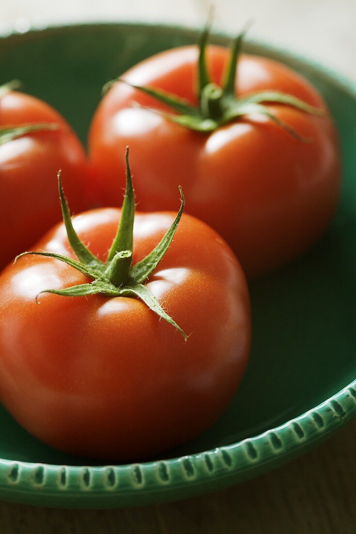 Three tomatoes in ceramic bowl