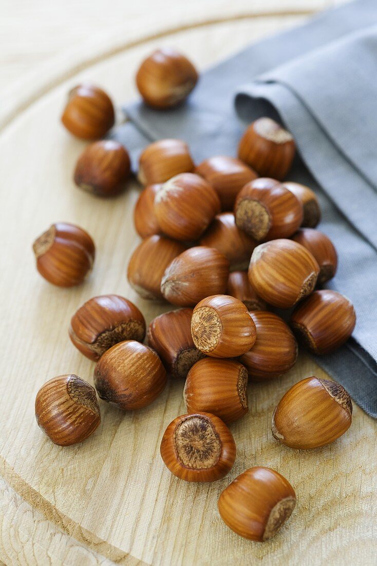 Unshelled hazelnuts on wooden board