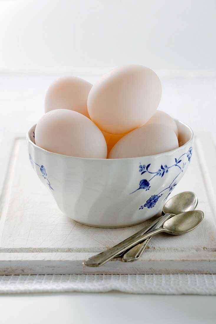 Duck eggs in ceramic bowl, spoons