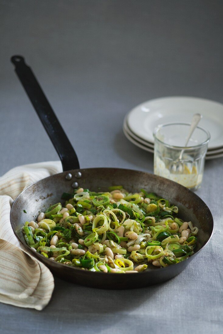 Leeks and cannellini with mustard sauce in frying pan