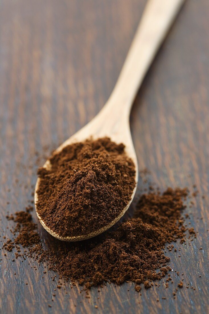 Ground coffee on wooden spoon