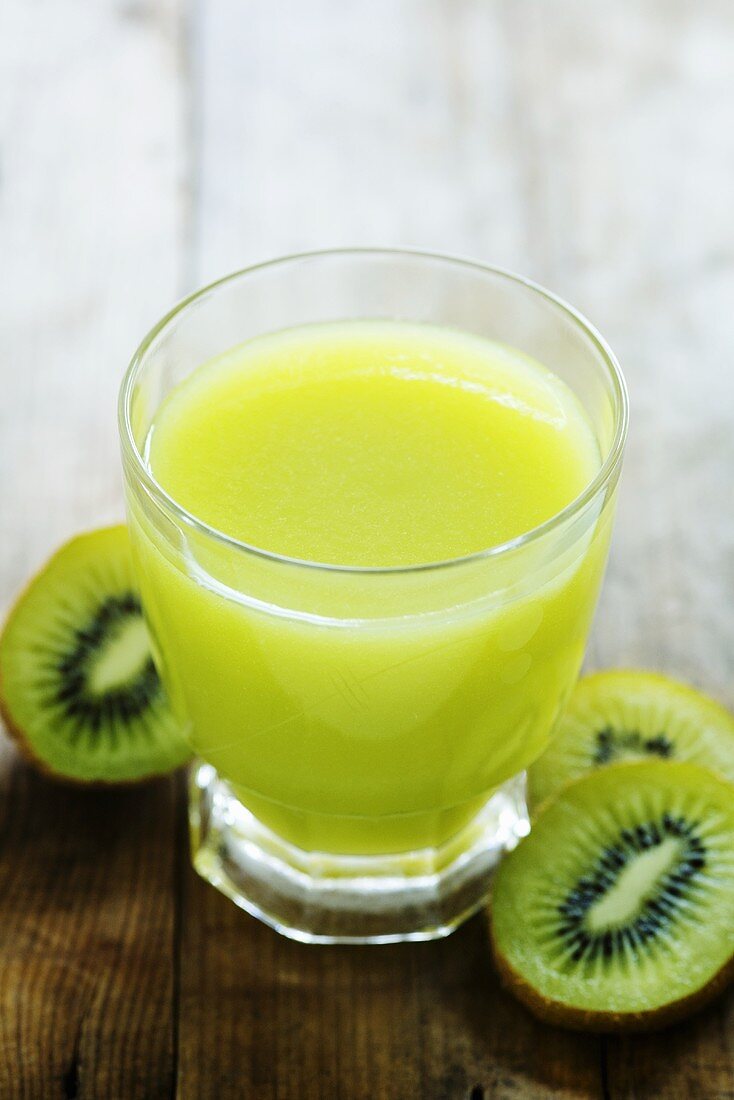 Kiwi fruit juice in glass, slices of kiwi fruit beside it