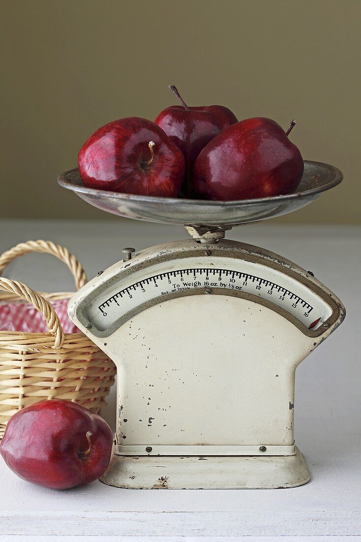 Several red apples on old kitchen scales
