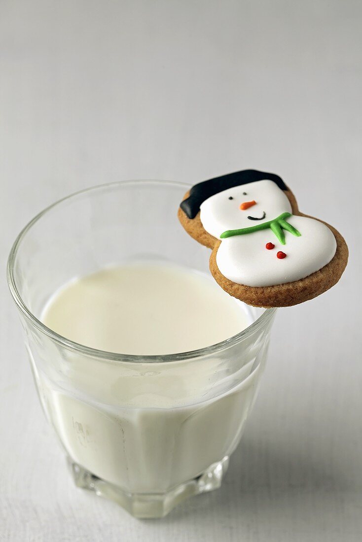 Snowman biscuit on glass of milk